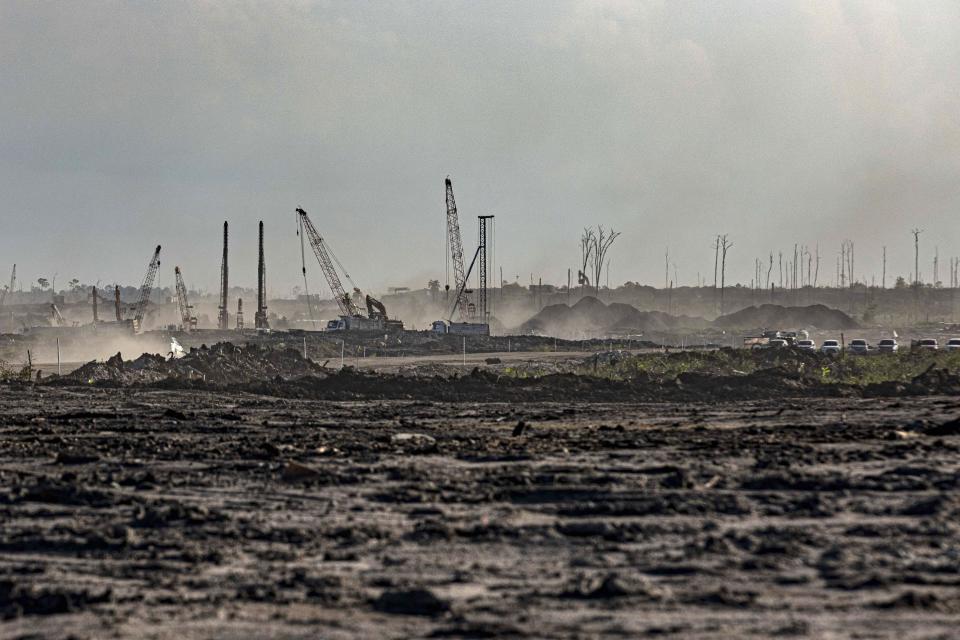 Construction equipment is used at the site of the Kalimantan Industrial Park Indonesia (KIPI) in Mangkupadi, Bulungan, North Kalimantan, Indonesia on Thursday, Aug. 24, 2023. The vast industrial park being built on the tropical island of Borneo that has attracted billions of dollars in foreign and domestic investment is damaging the environment in an area where endangered animals live and migrate. (AP Photo/Yusuf Wahil)