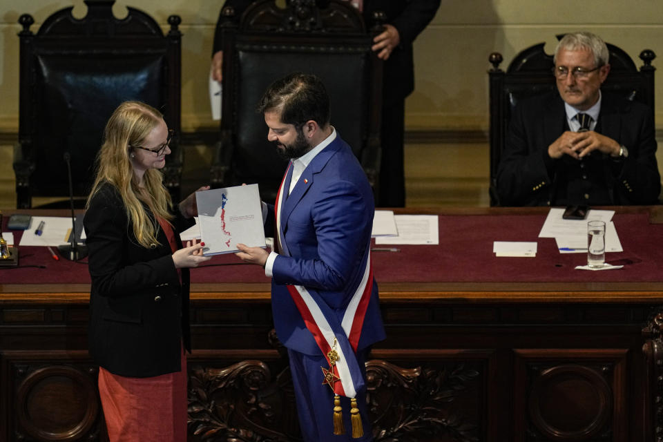 La presidenta del Consejo Constitucional, Breatriz Hevia le presenta al presidente chileno Gabriel Boric el borrador final de la nueva Constitución durante una ceremonia en el antiguo edificio del Congreso Nacional en Santiago, Chile, el martes 7 de noviembre de 2023. Los votantes decidirán el 17 de diciembre si aceptan o rechazan la nueva Constitución. (AP Foto/Esteban Félix)