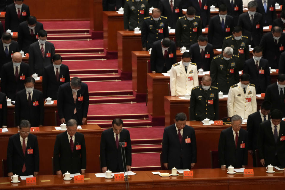 Attendees bow their heads to observe a moment of silence for fallen comrades during the opening ceremony of the 20th National Congress of China's ruling Communist Party held at the Great Hall of the People in Beijing, China, Sunday, Oct. 16, 2022. China on Sunday opens a twice-a-decade party conference at which leader Xi Jinping is expected to receive a third five-year term that breaks with recent precedent and establishes himself as arguably the most powerful Chinese politician since Mao Zedong. (AP Photo/Mark Schiefelbein)