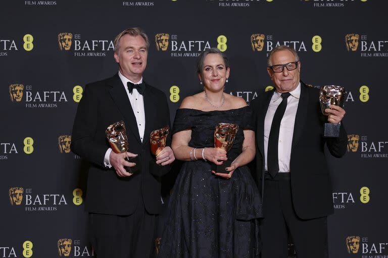 Christopher Nolan, a la izquierda, junto a sus dos productores de Oppenheimer, la película que cumplió con lo que se esperaba de ella en la premiación