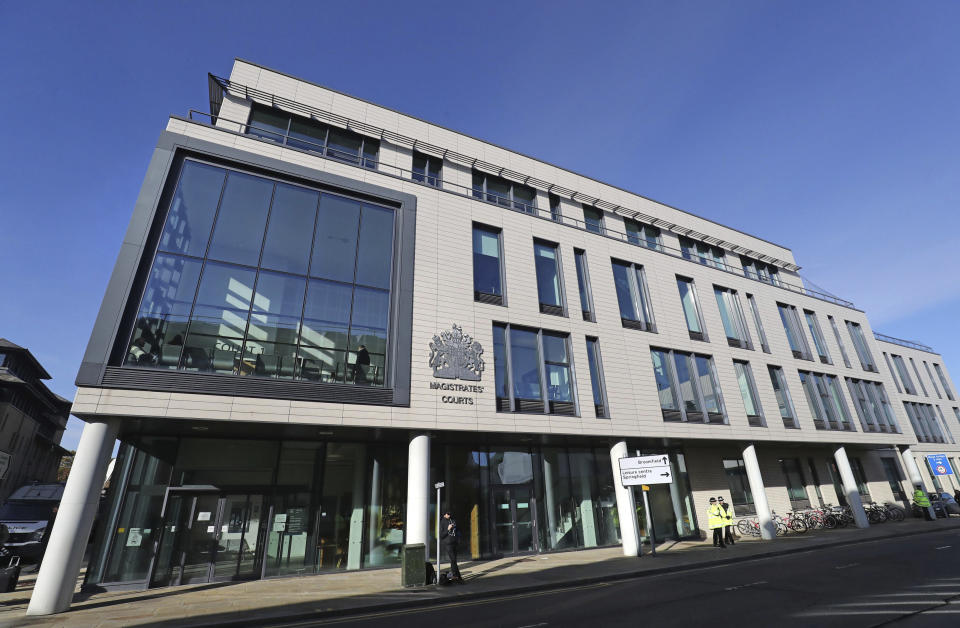 Police stand outside Chelmsford Magistrates' Court, England, where lorry driver Maurice Robinson, 25, will appear on Monday Oct. 28, 2019. Authorities found 39 people dead in a truck in an industrial park in England on Wednesday and arrested the driver on suspicion of murder in one of Britain's worst human-smuggling tragedies. (Gareth Fuller/PA via AP)