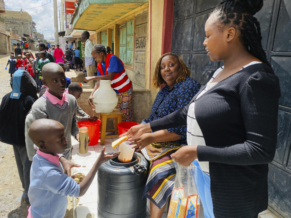 Njeri Migwi, a woman human rights defender and the Co-Founder of Usikimye (Swahili word for 'Don't be Silent'), an organization working towards ending the prevalence of sexual and gender-based violence (GBV), serves lunch to children from her school feeding program in downtown Nairobi, Kenya, Monday, March 4 2024. Migwi, is on the frontline of a war against a silent epidemic of Gender Based Violence or GBV in Kenya that also afflicts many Sub-Saharan African countries, with devasting consequences on individuals, societies and even the countries’ economies. (AP Photo/Jackson Njehia)