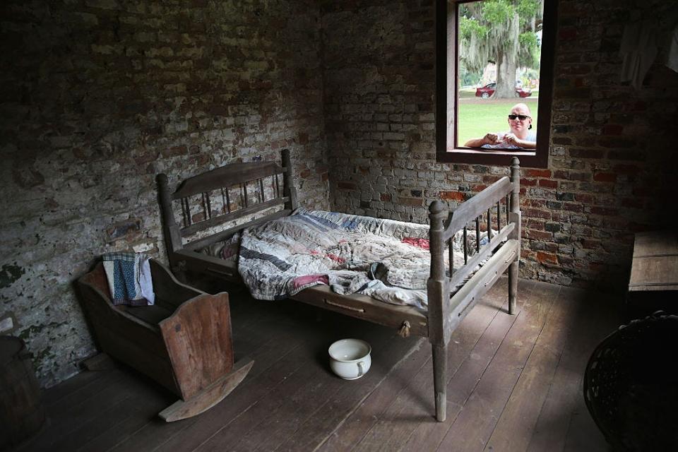 A tourist looks into what was once enslaved people's quarters at Boone Hall Plantation in Mount Pleasant, South Carolina.