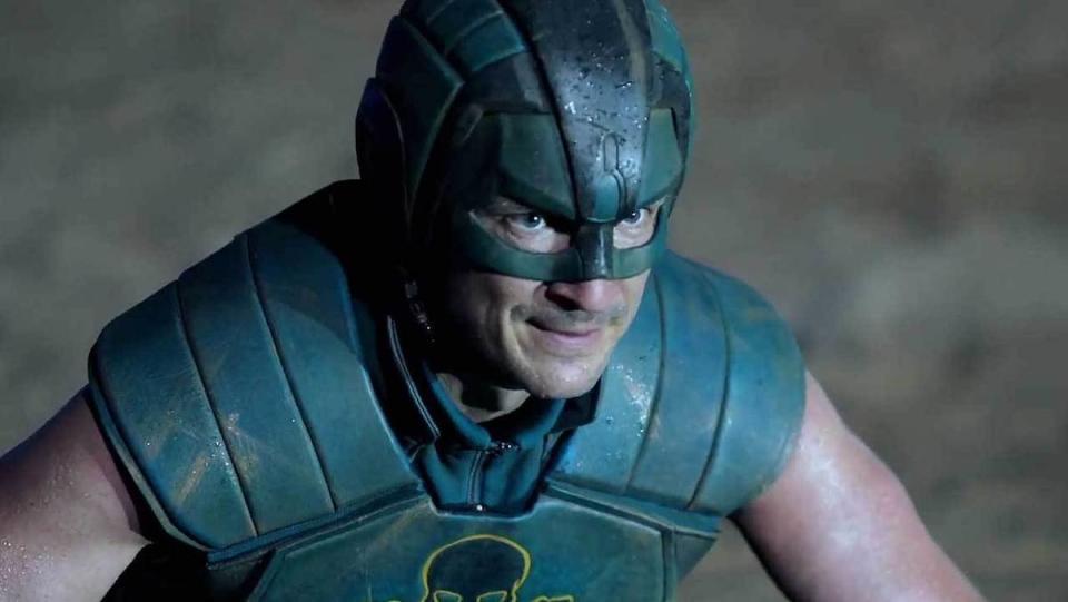 Nathan Fillion as TDK in his armor and helmet, sweating, in The Suicide Squad