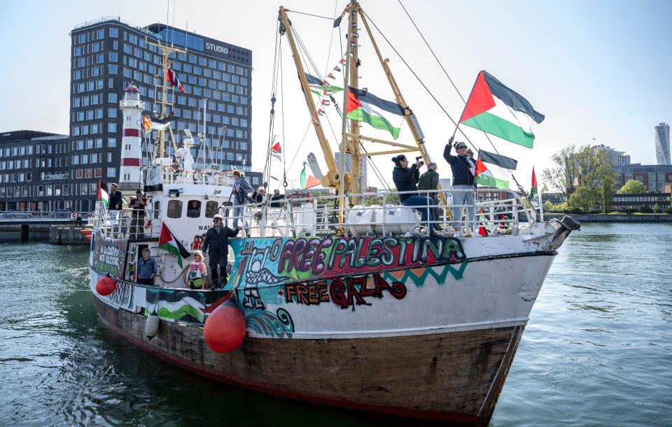 Demonstrators with Palestinian flags on the quay as the Ship to Gaza boat 'Handala' steers in to dock at the Steamboat Bridge in the harbour of Malmö. (Alamy)