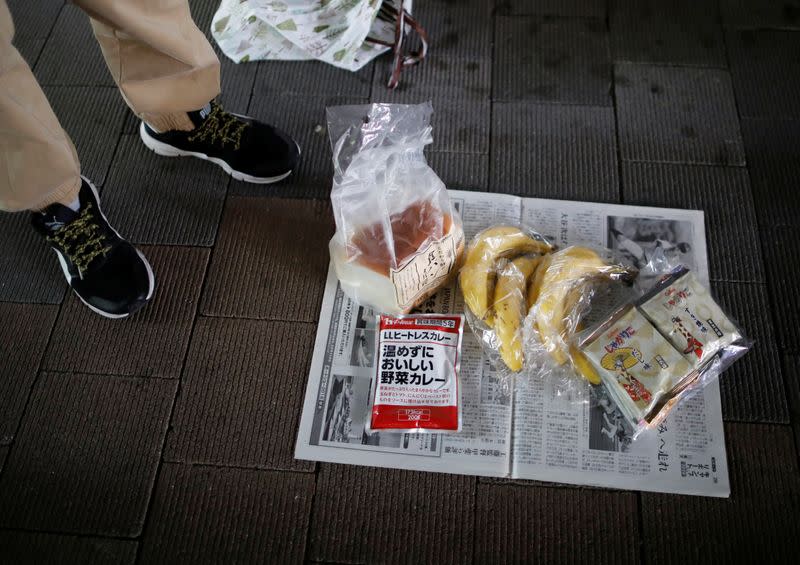 An elderly man who lost his stable job caused by the impacts of the coronavirus disease (COVID-19) outbreak, shows off foods which he received at food aid handouts, in Tokyo