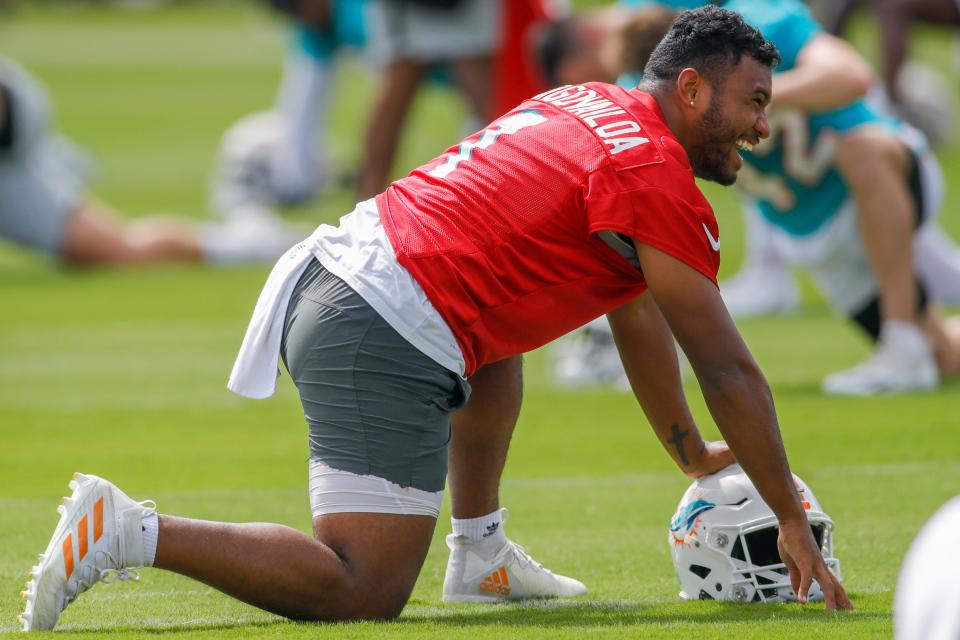 Aug 1, 2022; Miami Gardens, Florida, US; Miami Dolphins quarterback Tua Tagovailoa (1) reacts from the field while stretching during training camp at Baptist Health Training Complex. Mandatory Credit: Sam Navarro-USA TODAY Sports