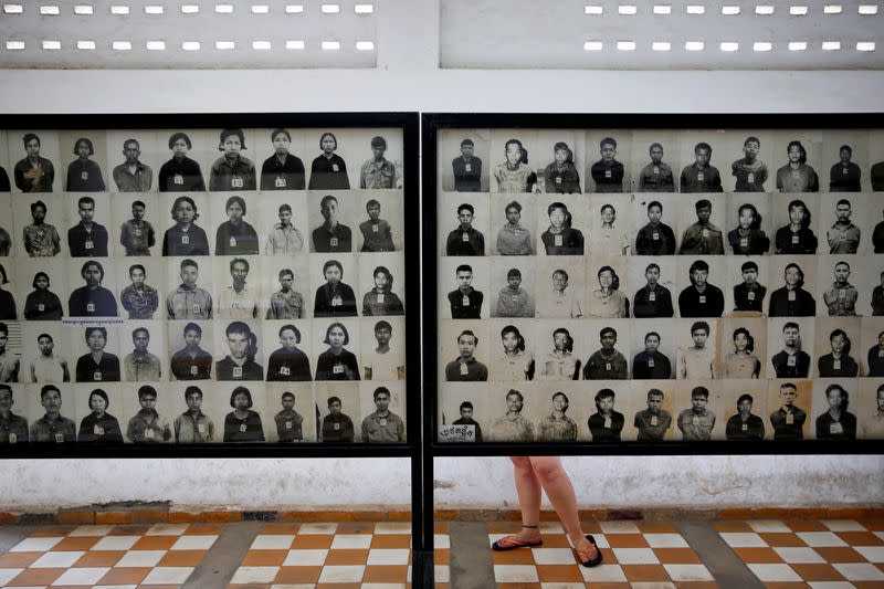 A visitor looks at pictures of victims of Khmer Rouge regime at the former notorious Tuol Sleng prison that is now the Genocide Museum, in Phnom Penh