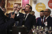 French President Emmanuel Macron drinks wine during a visit to the International Agriculture Fair (Salon de l'Agriculture) at the Porte de Versailles exhibition center in Paris, Saturday, Feb. 22, 2020. (Christophe Petit Tesson/Pool via AP)