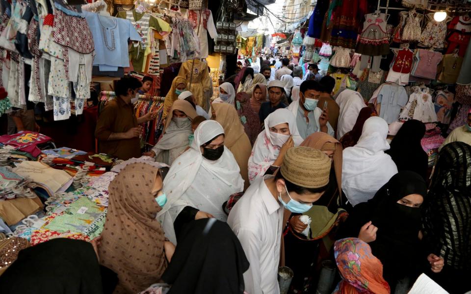 People ignore social distancing while shopping at a market after the government announced new restrictions to help control the spread of the coronavirus, in Peshawar, Pakistan - Muhammad Sajjad/AP