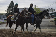 Exercise rider Jade Cunningham, left, walks with Preakness entrant Ram and trainer D. Wayne Lukas after a training session ahead of the Preakness Stakes horse race at Pimlico Race Course, Wednesday, May 12, 2021, in Baltimore. (AP Photo/Julio Cortez)