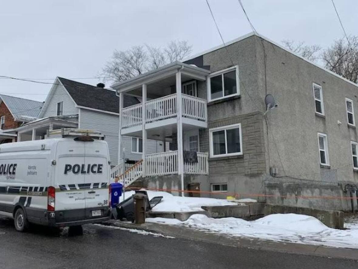 A police van is parked outside an apartment building on rue Frontenac in Gatineau, Que., on March 26, 2023. One person is dead following an early morning fire there. (Rebecca Kwan/Radio-Canada - image credit)