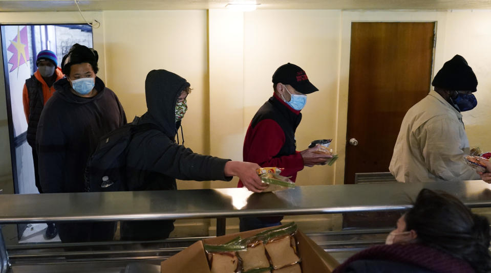 People seeking shelter from sup-freezing temperatures receive a meal at a make-shift warming shelter at Travis Park Methodist Church, Tuesday, Feb. 16, 2021, in San Antonio. (AP Photo/Eric Gay)