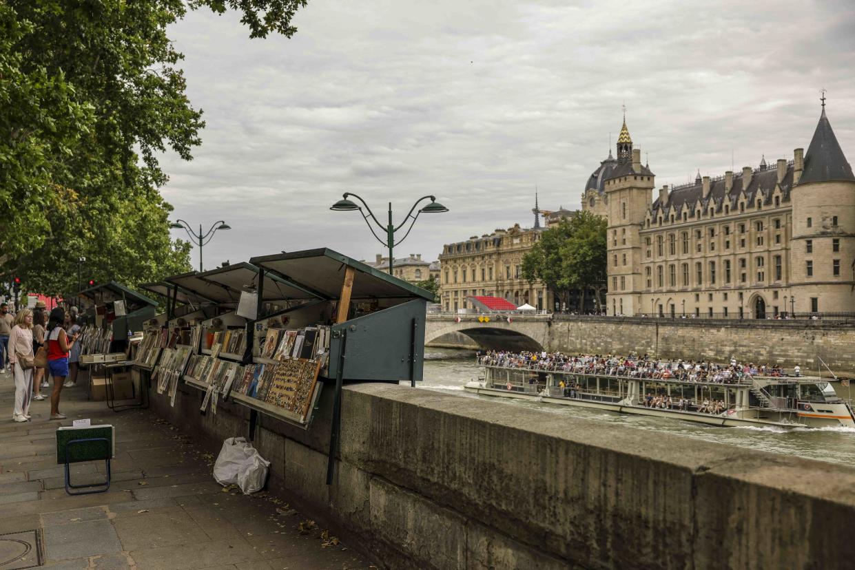 PARIS, FRANCE - JULY 14: Visitors shop at the the Bouquinistes, booksellers of used and antiquarian books and rare vintage postcards on July 14, 2024 in Paris, France. (Photo by Maja Hitij/Getty Images)