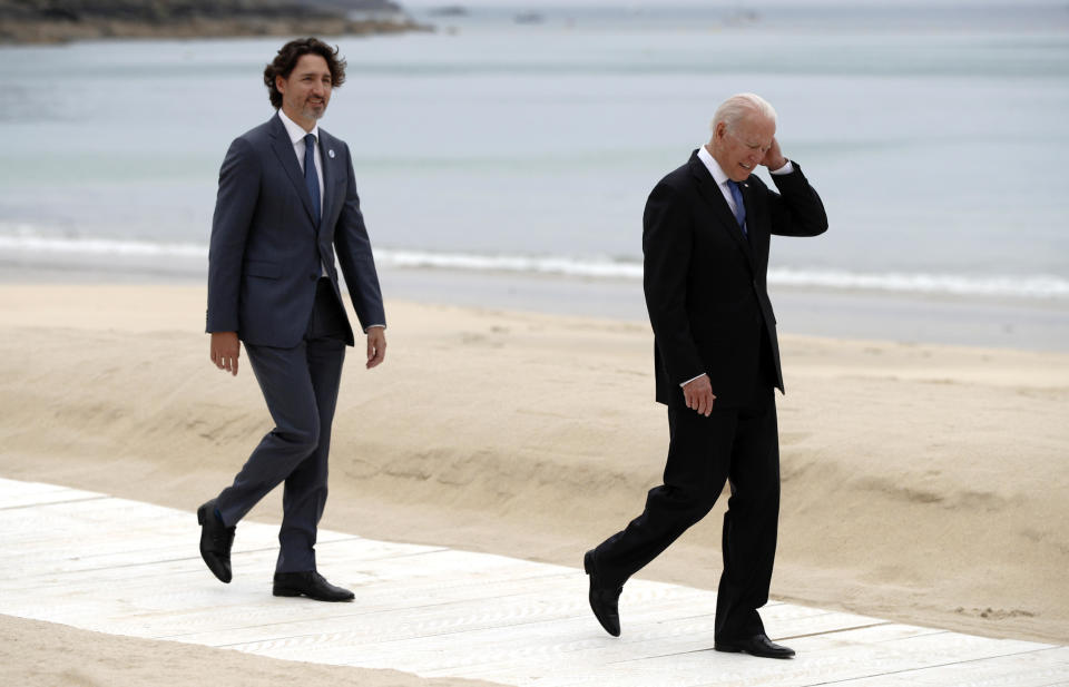 U.S. President Joe Biden, right, and Canadian Prime Minister Justin Trudeau walk on the boardwalk during arrivals for the G7 meeting at the Carbis Bay Hotel in Carbis Bay, St. Ives, Cornwall, England, on Friday, June 11, 2021, / Credit: Phil Noble / AP