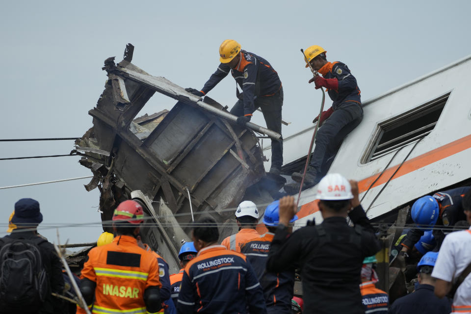 Rescuers inspect the wreckage after the collision between two trains in Cicalengka, West Java, Indonesia, Friday, Jan. 5, 2024. The trains collided on Indonesia's main island of Java on Friday, causing several carriages to buckle and overturn, officials said. (AP Photo/Achmad Ibrahim)