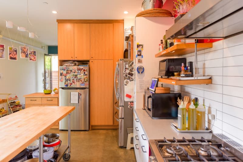 Wood pantry surrounding kitchen of communal home.