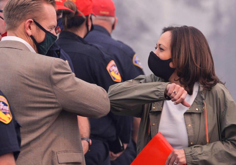 Fresno County Supervisor Nathan Magsig, left, elbows Sen. Kamala Harris in greeting at Pine Ridge Elementary School Tuesday, Sept. 15, 2020.