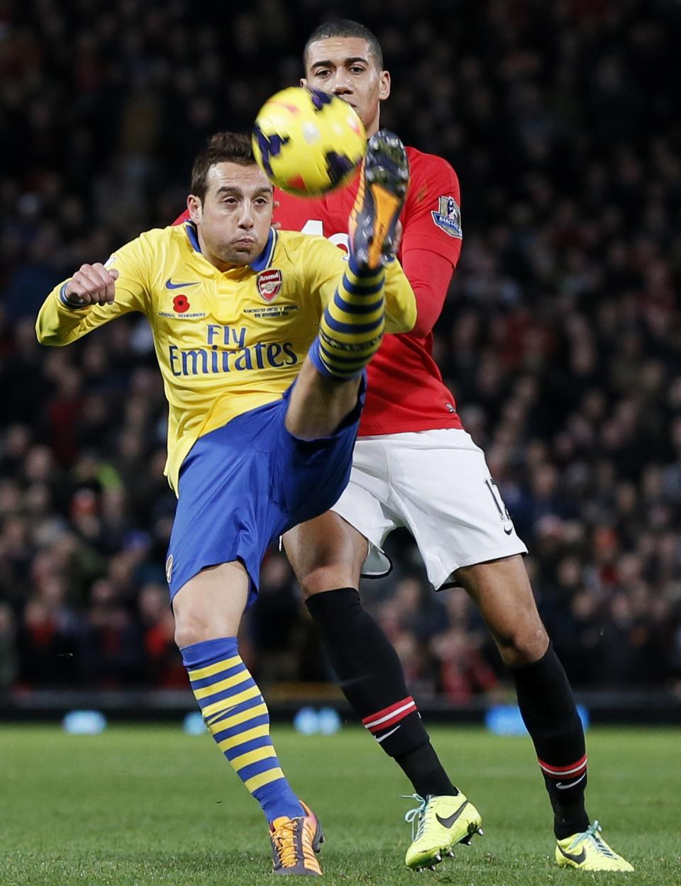 Manchester United's Chris Smalling challenges Arsenal's Olivier Giroud during their English Premier League soccer match at Old Trafford in Manchester, northern England, November 10, 2013.