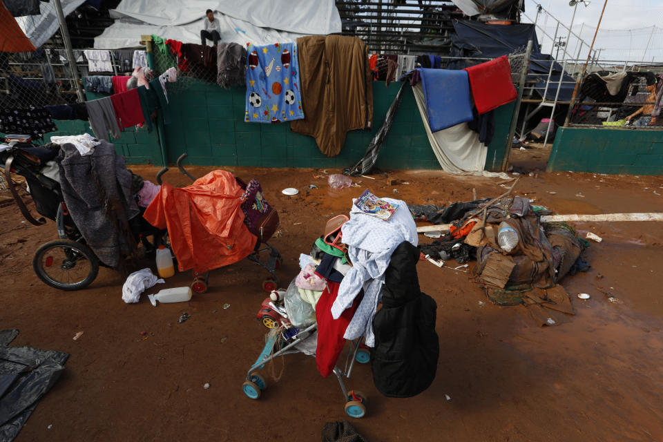 Belongings are stacked on strollers while mattresses and blankets hang on lines to dry, a day after heavy rains, inside the Benito Juarez sports complex in Tijuana, Mexico, Friday, Nov. 30, 2018. Authorities in the Mexican city of Tijuana have begun moving some of more than 6,000 Central American migrants from an overcrowded shelter on the border to an events hall further away.(AP Photo/Rebecca Blackwell)