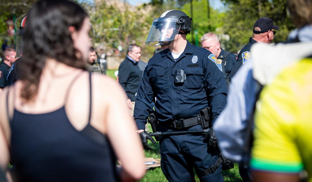 An Indiana State Police officer standsin front of demonstrators at Dunn Meadow on Thursday, April 25, 2024.