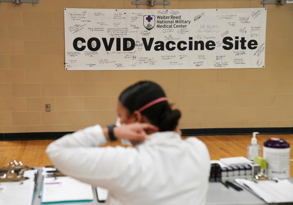 A medical worker adjusts her mask as U.S. President Joe Biden visits a vaccination site at Walter Reed National Military Medical Center in Bethesda, Maryland, U.S. January 29, 2021. REUTERS/Kevin Lamarque