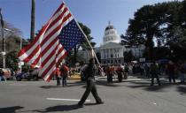 A protester carries an upside-down American flag during the Occupy the Capitol protest at the state Capitol in Sacramento, California March 5, 2012.