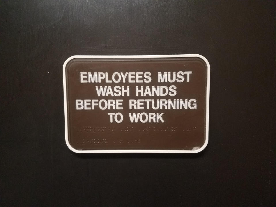 An "Employees must wash hands before returning to work" sign