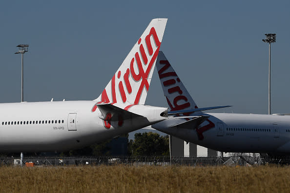 Virgin Australia aircrafts are seen parked in the Brisbane Airport. Passengers on board flight VA962 have been warned to monitor for coronavirus symptoms after a woman tested positive..