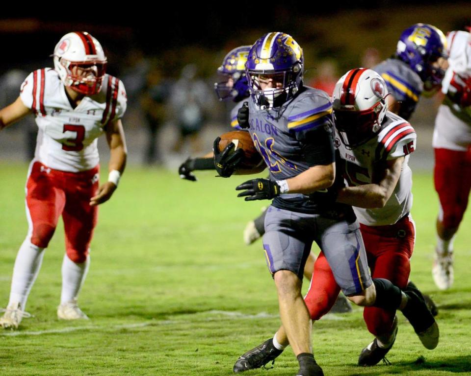 Escalon running back Jamin Miller (26) tries to break free from a Ripon defender during a game between Escalon High School and Ripon High School in Escalon, California on October 20, 2023. 