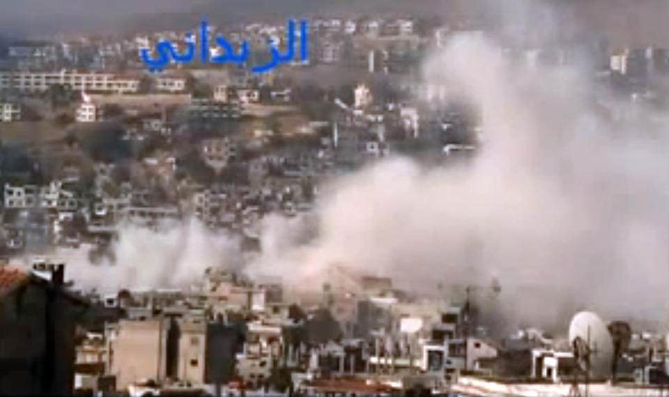 In this image taken from video obtained from the Shaam News Network, which has been authenticated based on its contents and other AP reporting, smoke rises from buildings due to government shelling in the Damascus suburb of Zabadani, Syria, on Friday, Nov. 23, 2012. At the same time, Syrian forces are raiding another neighborhood showing how fighting is spreading in Damascus, once a stronghold of President Bashar Assad. (AP Photo/Shaam News Network via AP video)