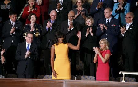 U.S. first lady Michelle Obama waves from her box in the gallery with Connecticut Governor Dannel Malloy (L) on one side and a symbolic empty seat for victims of gun violence between her and Dr. Jill Biden (R) while attending U.S. President Barack Obama's State of the Union address to a joint session of Congress in Washington, January 12, 2016. REUTERS/Kevin Lamarque