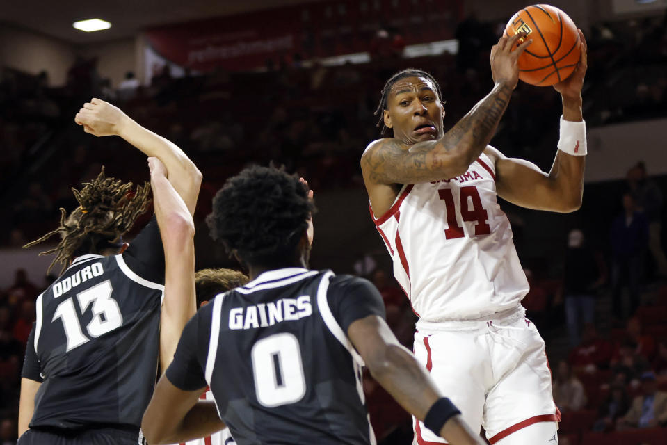 Oklahoma forward Jalon Moore (14) grabs a rebound near Providence forward Josh Oduro (13) and guard Ticket Gaines (0) during the first half of an NCAA college basketball game, Tuesday, Dec. 5, 2023, in Norman, Okla. (AP Photo/Nate Billings)