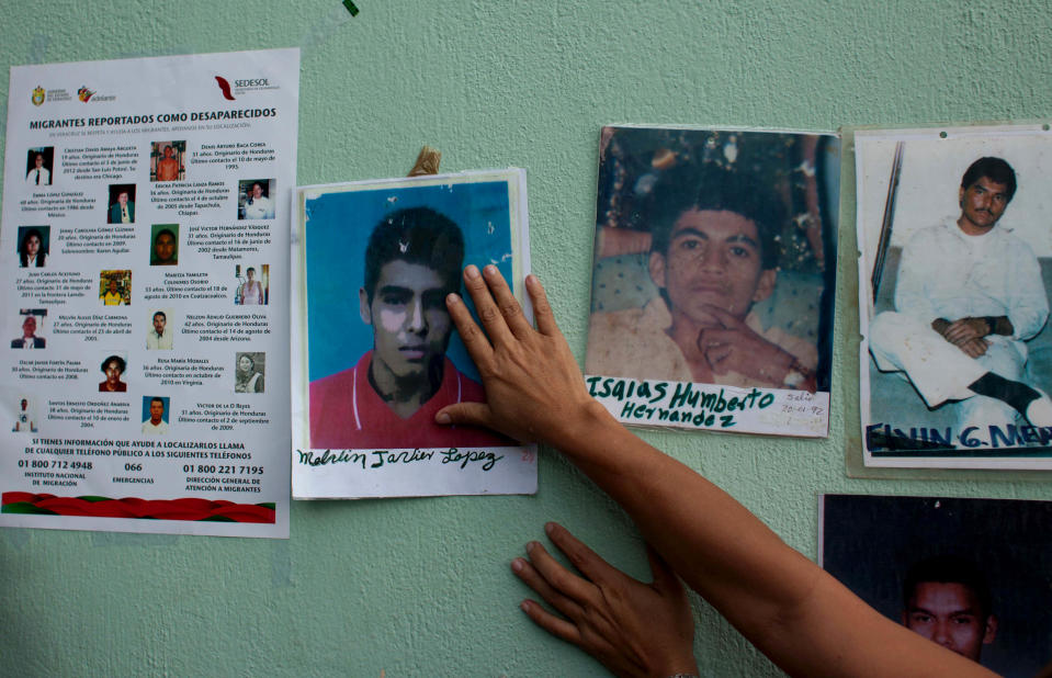 In this photo taken on Thursday, Oct. 18, 2012, a member of the Convoy of Central American Mothers tapes a photograph of a missing relative to the wall of the railway station in Reynosa, Mexico. The convoy mostly comprised of women from Central America, travel 2,800 miles through Mexico to search for their relatives who left for a better life and then disappeared on their journey to the U.S. (AP Photo)