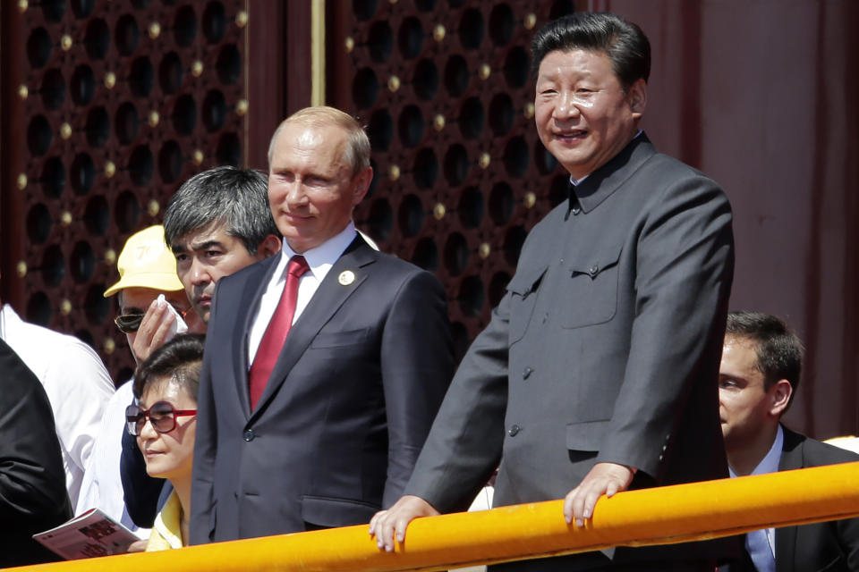 FILE - In this Sept. 3, 2015, file photo, Chinese President Xi Jinping, right, Russian President Vladimir Putin, center observe a parade commemorating the 70th anniversary of Japan's World War II defeat, from Tiananmen Gate in Beijing. Xi has an ambitious goal for China: to achieve "national rejuvenation" as a strong and prosperous nation by 2049, which would be the 100th anniversary of Communist Party rule. One problem: U.S. President Donald Trump wants to make the United States great again too. (AP Photo/Ng Han Guan, File)