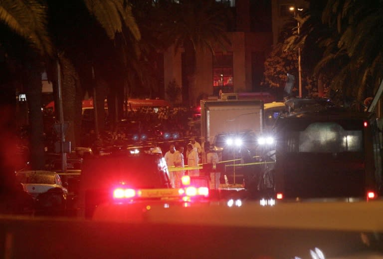 Police and forensics teams gather at the site of a bomb blast on a bus (R) transporting Tunisia's presidential guard in central Tunis on November 24, 2015