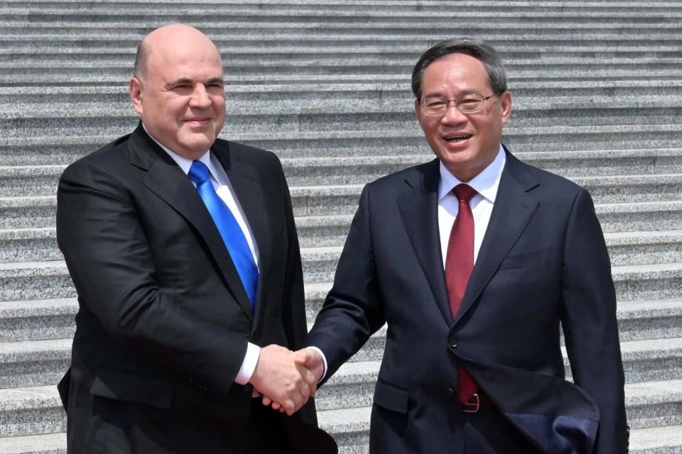 Russian Prime Minister Mikhail Mishustin, left, and Chinese Premier Li Qiang attend a welcoming ceremony in Beijing, China, Wednesday, May 24, 2023. (Alexander Astafyev, Sputnik, Government Pool Photo via AP)