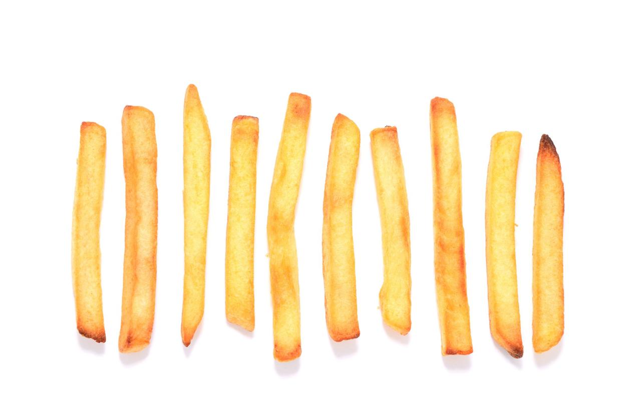 French fries in a row on white background