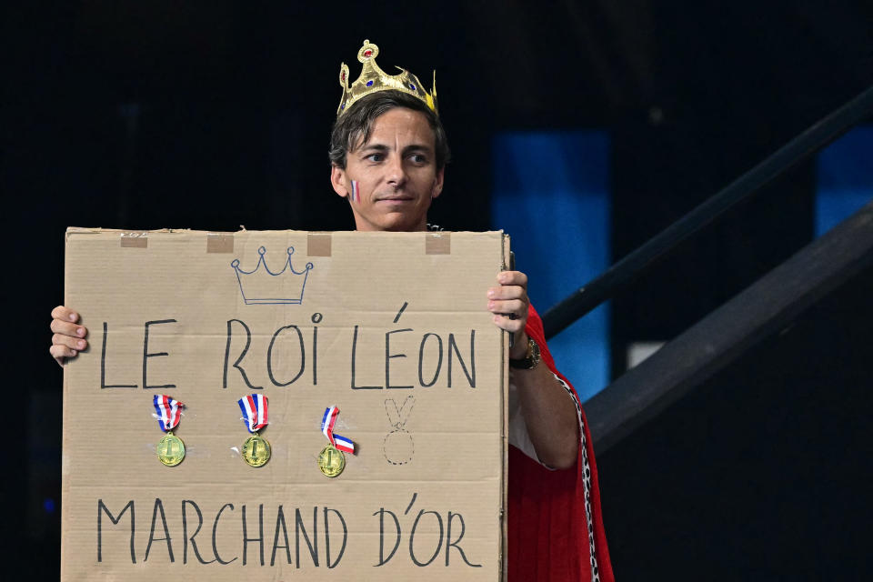 A supporter of France's Leon Marchand holds a placard while attending the swimming events during the Paris 2024 Olympic Games at the Paris La Defense Arena in Nanterre, west of Paris, on August 2, 2024. (Photo by Manan VATSYAYANA / AFP) (Photo by MANAN VATSYAYANA/AFP via Getty Images)