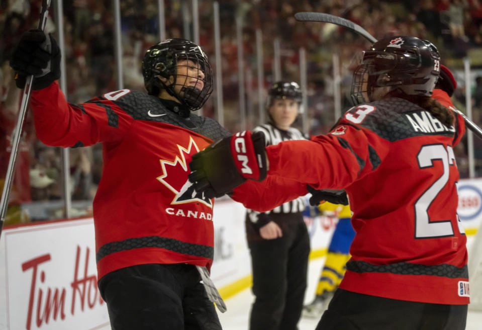 Canada forward Sarah Nurse (20) is congratulated by defender Erin Ambrose (23) after scoring against Sweden during the second period of a quarterfinal match at the women's world hockey championships in Brampton, Ontario, Thursday, April 13, 2023. (Frank Gunn/The Canadian Press via AP)