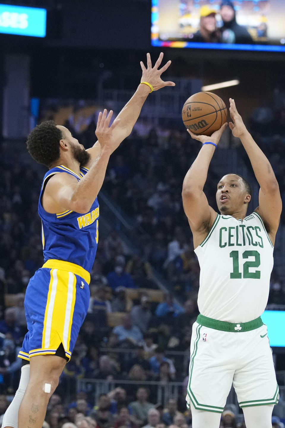 Boston Celtics forward Grant Williams, right, shoots a 3-point basket over Golden State Warriors guard Stephen Curry during the first half of an NBA basketball game in San Francisco, Saturday, Dec. 10, 2022. (AP Photo/Godofredo A. Vásquez)