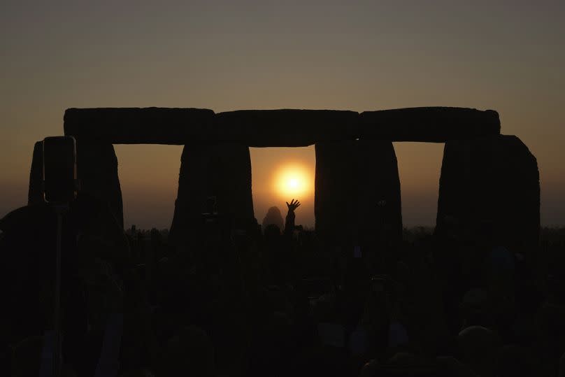 Los juerguistas se reúnen en el antiguo círculo de piedras de Stonehenge para celebrar el solsticio de verano, el día más largo del año, cerca de Salisbury, Inglaterra.