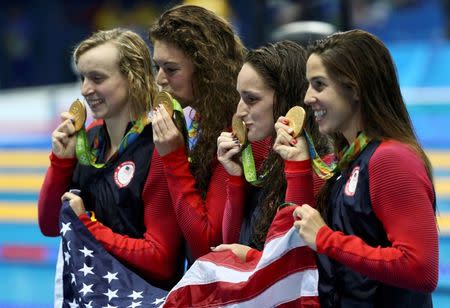 2016 Rio Olympics - Swimming - Victory Ceremony - Women's 4 x 200m Freestyle Relay Victory Ceremony - Olympic Aquatics Stadium - Rio de Janeiro, Brazil - 10/08/2016. Allison Schmitt (USA) of USA, Leah Smith (USA) of USA, Maya DiRado (USA) of USA and Katie Ledecky (USA) of USA pose with their gold medals and their national flag. REUTERS/Stefan Wermuth