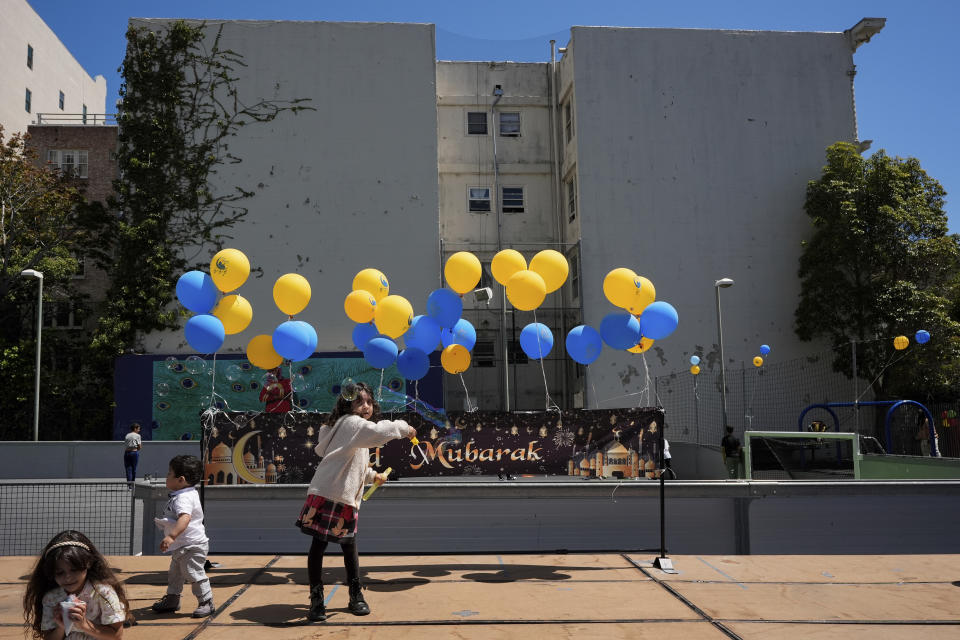 Six-year-old Leen Najjar, center, plays with a bubble-maker during an Eid celebration at the Tenderloin Recreation Center, Saturday, April 20, 2024, in San Francisco. (AP Photo/Godofredo A. Vásquez)