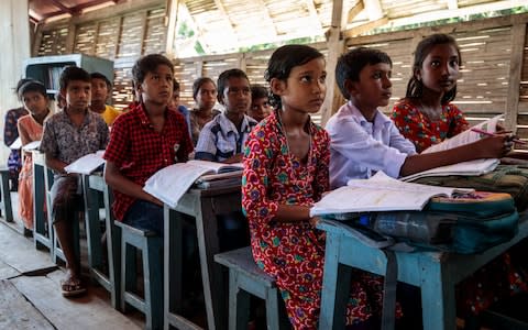 Children listen attentively to their teacher on a flloating school - Credit: Jack Taylor