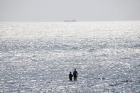 People enjoy the sun at the beach in the Black Sea in Odessa, Ukraine, Sunday, July 5, 2020. Tens of thousands of vacation-goers in Russia and Ukraine have descended on Black Sea beaches, paying little attention to safety measures despite levels of contagion still remaining high in both countries. (AP Photo/Sergei Poliakov)