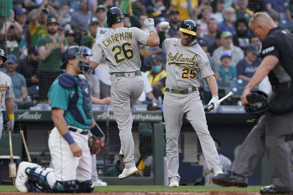 Oakland Athletics' Matt Chapman (26) greets Stephen Piscotty (25) after Chapman hit a solo home run during the third inning of the team's baseball game against the Seattle Mariners, Friday, July 23, 2021, in Seattle. (AP Photo/Ted S. Warren)