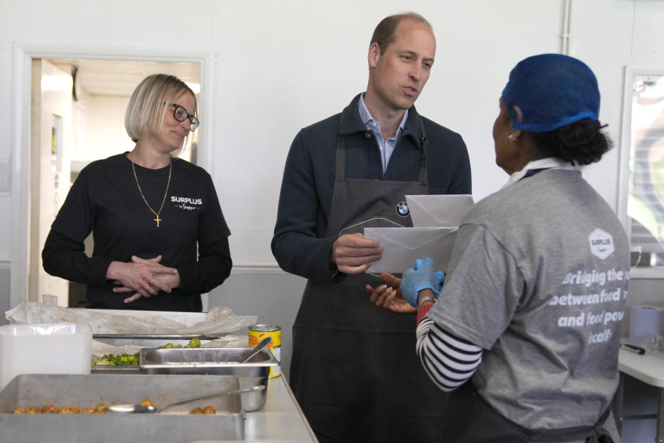 Britain's Prince William is given cards for his wife Kate, The Princess of Wales by volunteer Rachel Candappa during a visit to Surplus to Supper, in Sunbury-on-Thames, Surrey, England, Thursday, April 18, 2024. The Prince visited Surplus to Supper, a surplus food redistribution charity, to learn about its work bridging the gap between food waste and food poverty across Surrey and West London. (AP Photo/Alastair Grant, pool)
