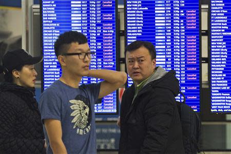 Travellers check an information monitor as weather causes flight cancellations and delays during a winter storm in Boston, Massachusetts, February 5, 2014. REUTERS/Dominick Reuter