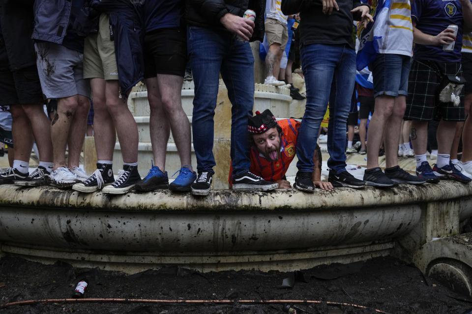 Scotland fans climbed on English playwright William Shakespeare's statue in Leicester Square prior to the Euro 2020 soccer championship group D match between England and Scotland, in London, Friday, June 18, 2021. (AP Photo/Kirsty Wigglesworth)